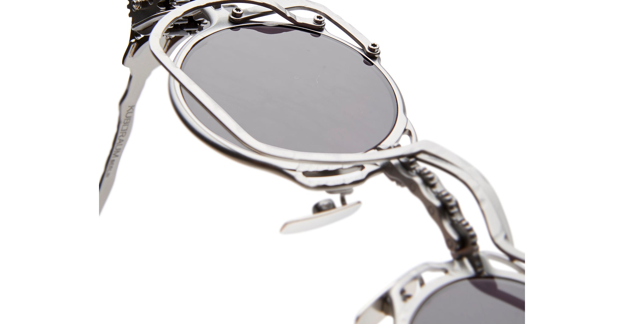 Close-up of KUBORAUM Z50 silver sunglasses with round dark lenses and detailed mechanical accents, front view.