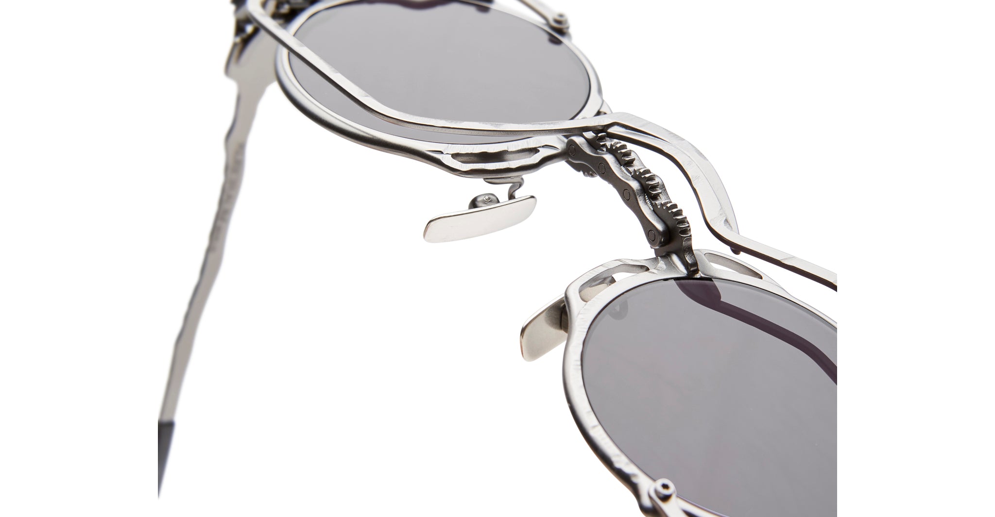 Close-up of Kuboraum Z50 round sunglasses with silver frames and mechanical-inspired hinges, front angle.