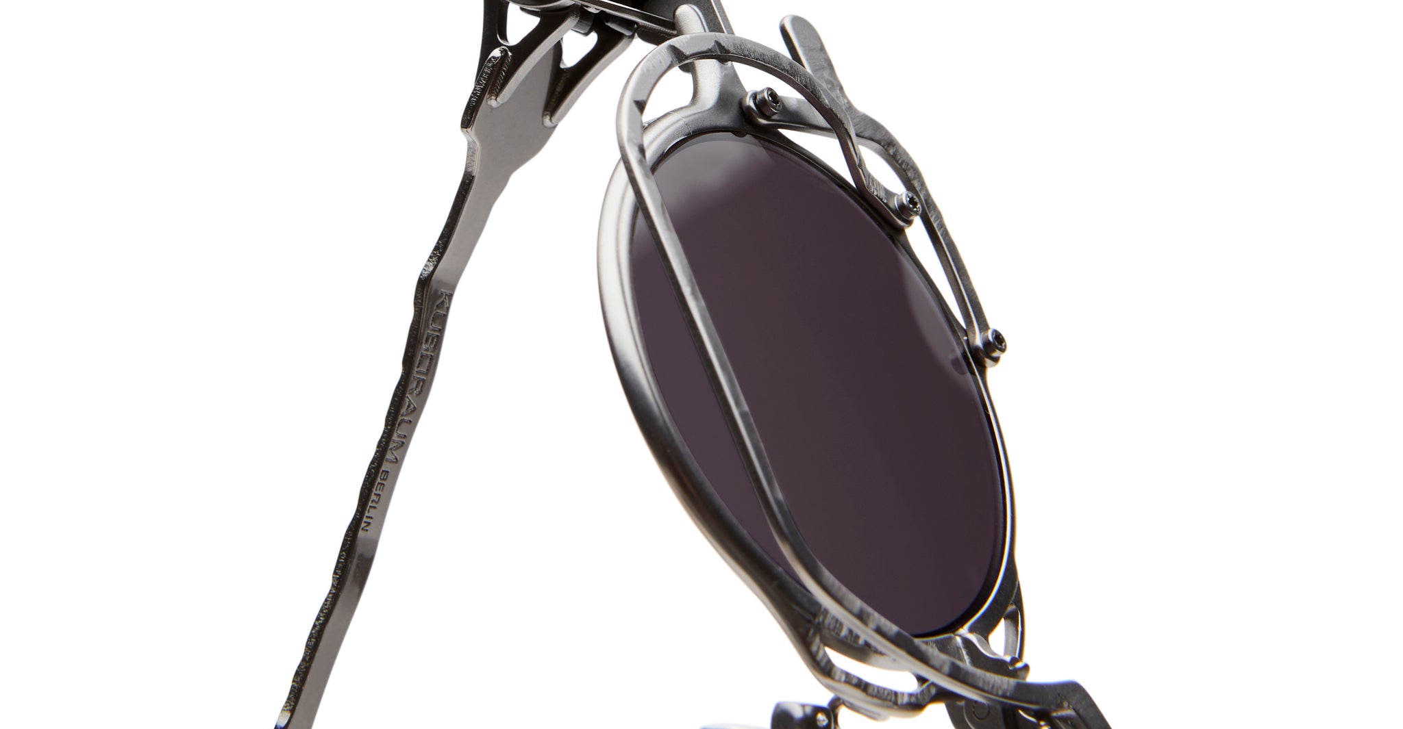 Close-up of KUBORAUM Z50 sunglasses, metallic frames with dark round lenses and detailed retro-style design, front angle view.