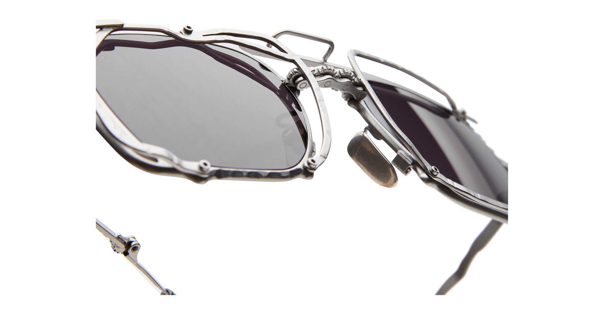Close-up of KUBORAUM Z51 sunglasses with metallic geometric frame and dark lenses, showing the unique shape from a front angle.