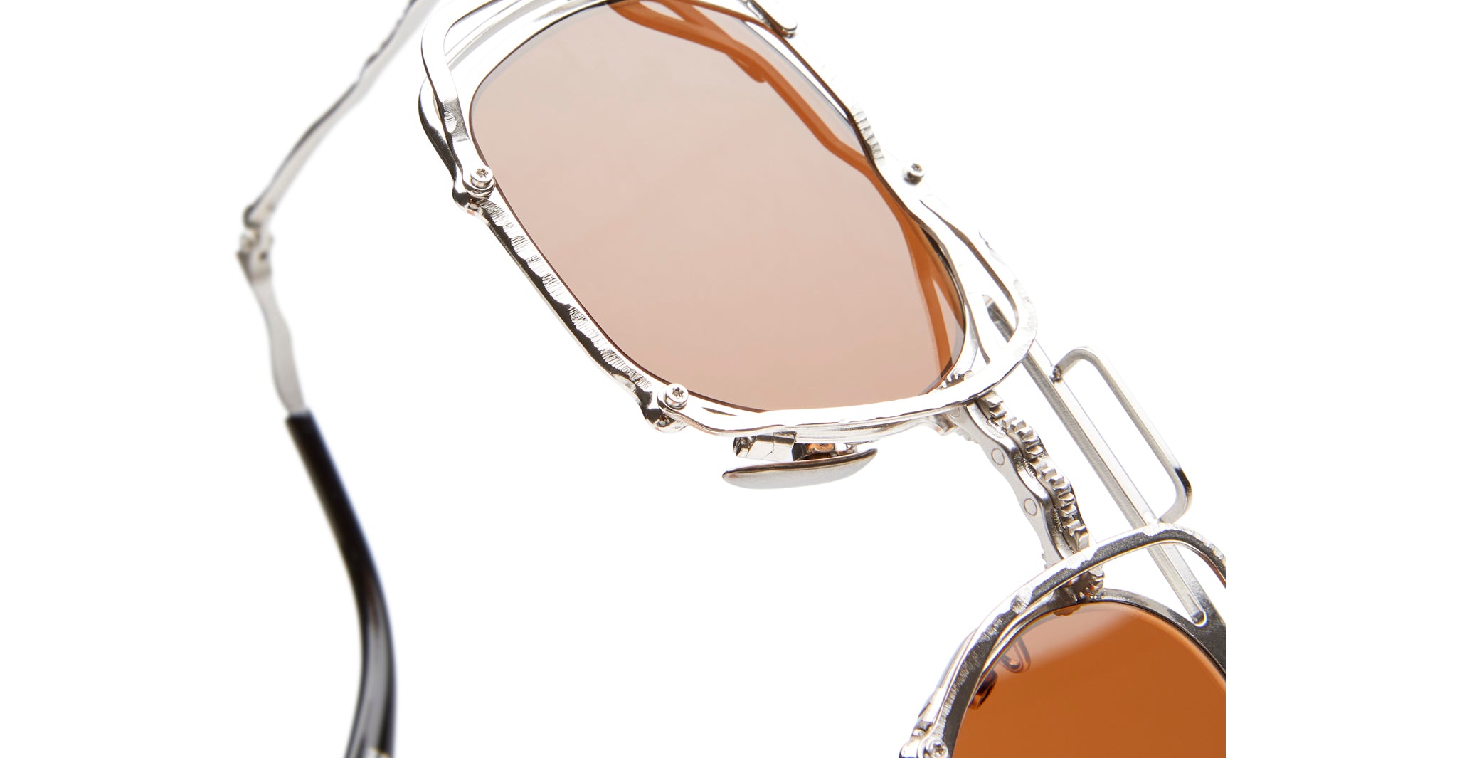 Close-up of KUBORAUM Z51 sunglasses featuring a silver metal frame and amber-tinted lenses, shown from the front angle.