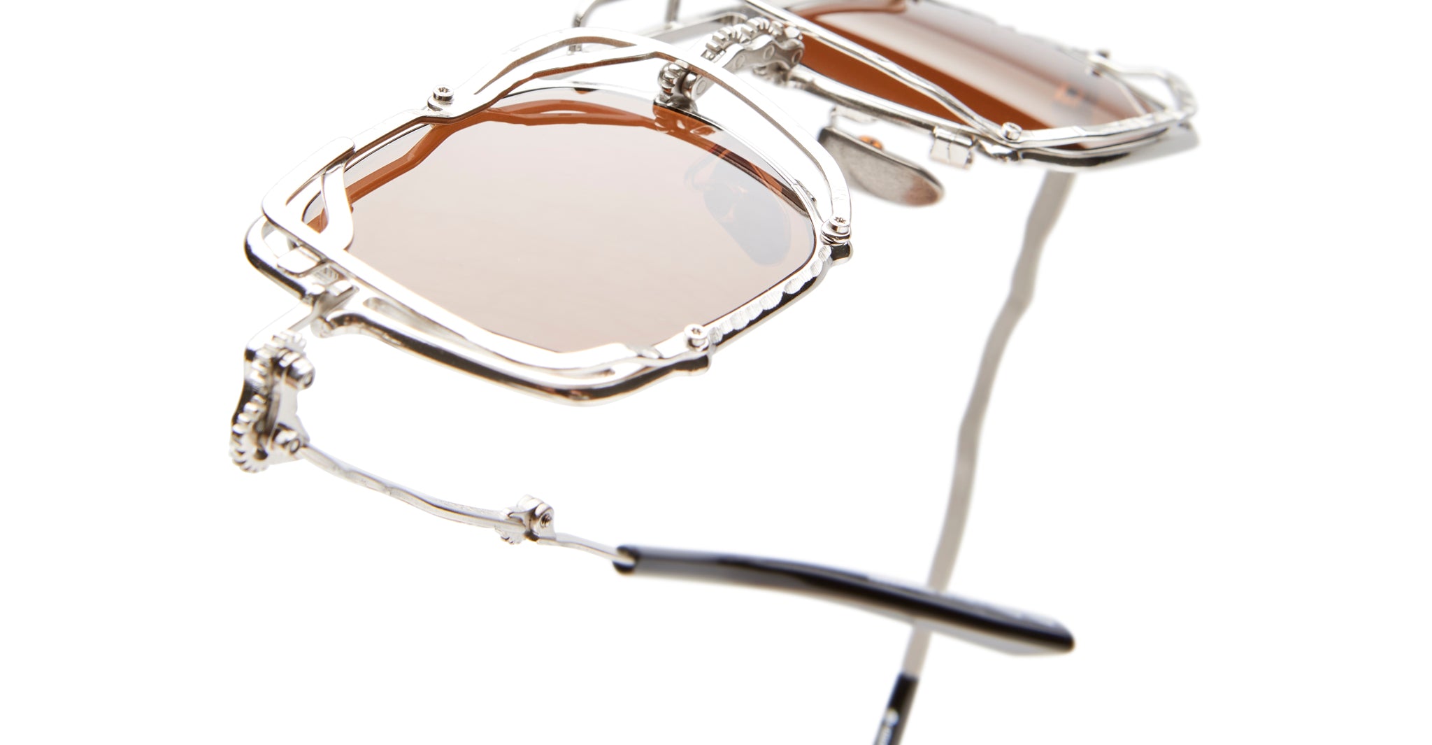 Close-up of KUBORAUM Z51 geometric metal frame sunglasses with brown-tinted lenses, front angle visible.