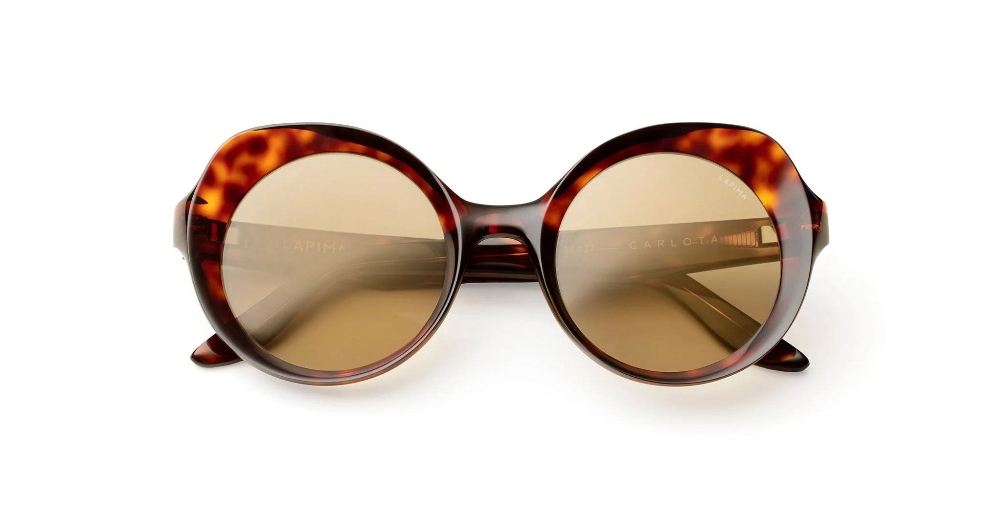 A pair of round, oversized tortoiseshell sunglasses with brown-tinted lenses, shown against a plain white background.