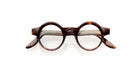 A pair of round, tortoiseshell eyeglasses with thick frames and clear lenses, displayed on a white background.