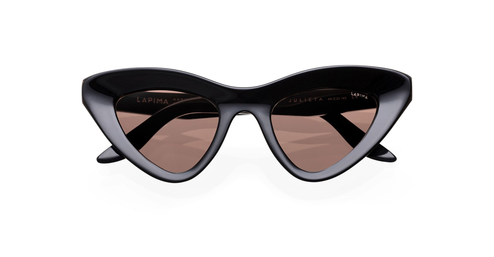 The Lapima Julieta by COMING SOON features bold, black cat-eye frames with dark brown tinted lenses. Displayed against a white background, these sunglasses offer a modern and stylish angular look.