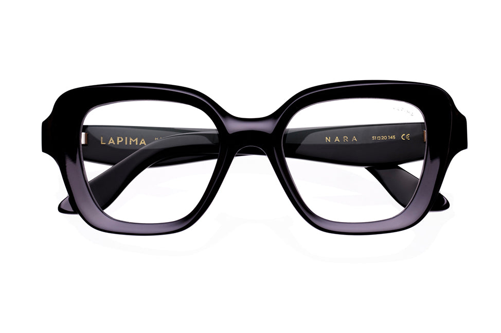 Front view of black, thick-rimmed rectangular eyeglasses with the brand name Lapima and model Nara printed in gold on the inside of the temples.