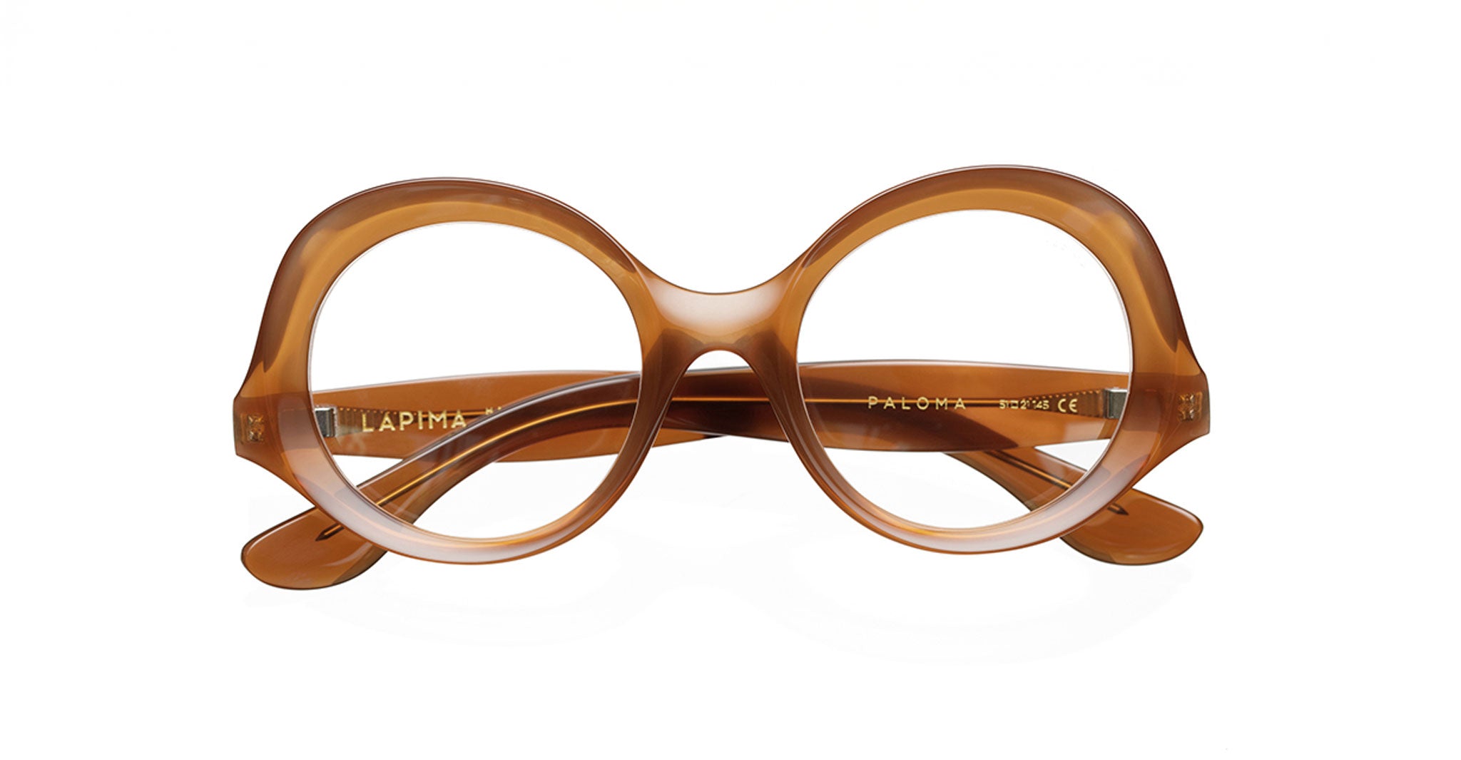 Lapima Paloma are round, oversized eyeglasses handcrafted in Brazil from thick Italian acetate. Shown front-facing on a white background, they feature wide arms and a bold, vintage-inspired brown design.
