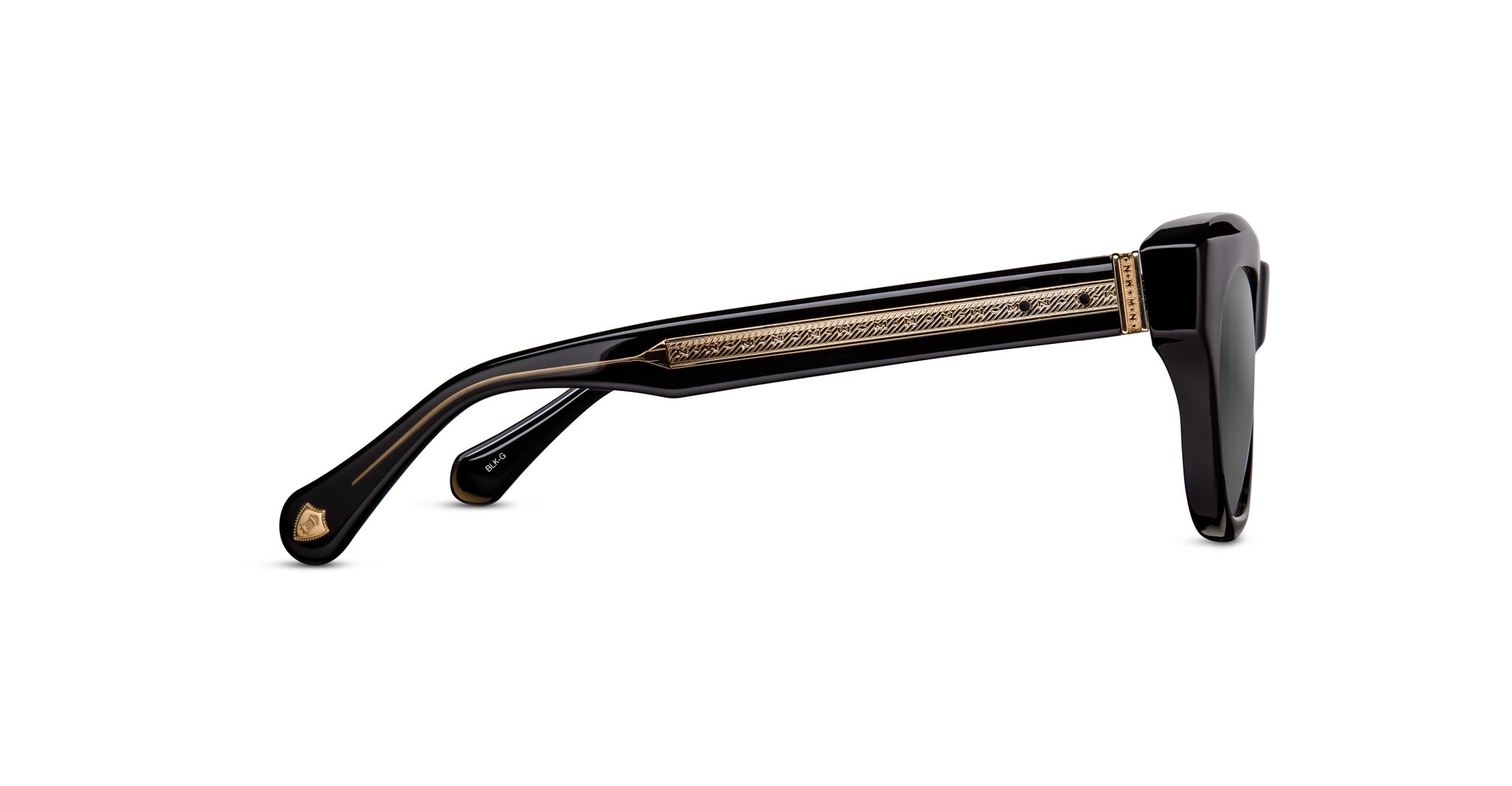 The Matsuda M1027 eyeglasses are shown in black from the side, featuring thick arms with decorative gold pattern and temple detailing.