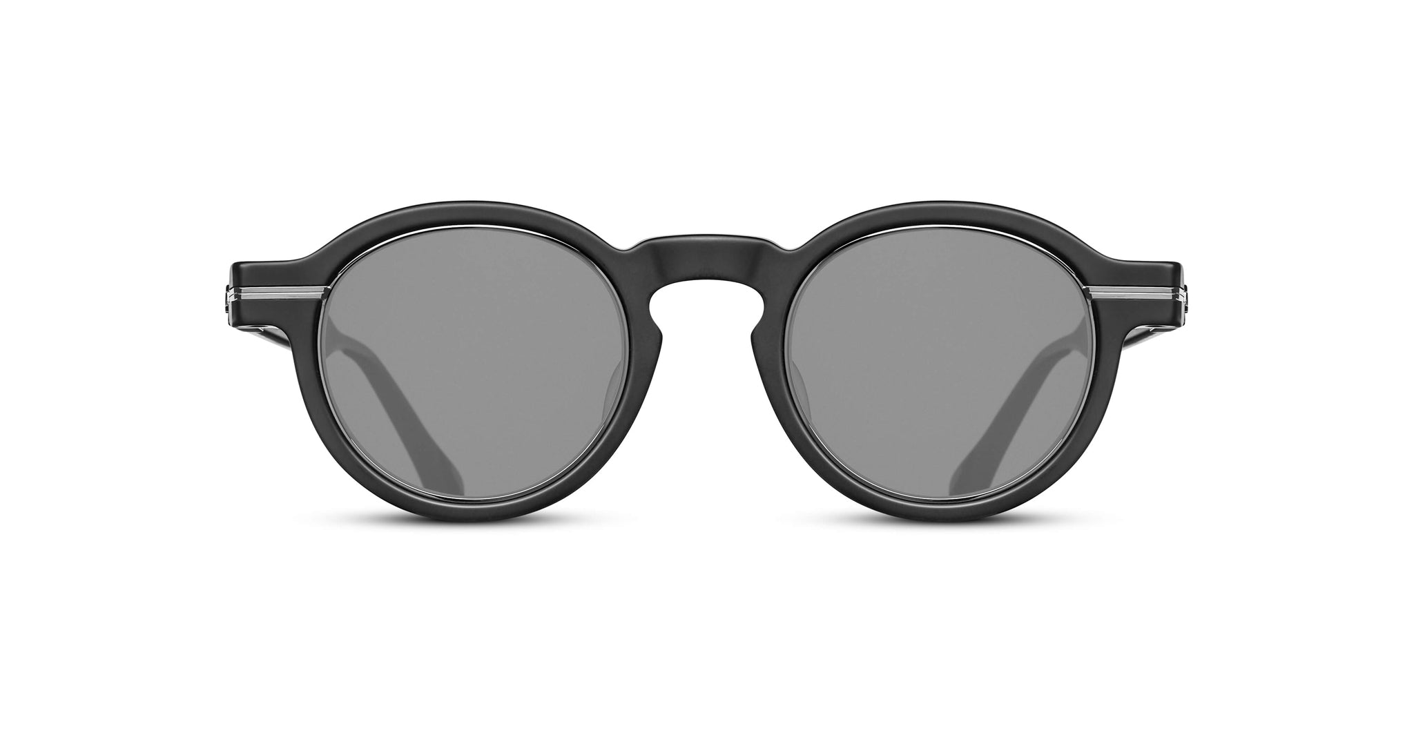 The Matsuda M2050 features round black sunglasses with thick frames and dark lenses, displayed from the front on a white background.