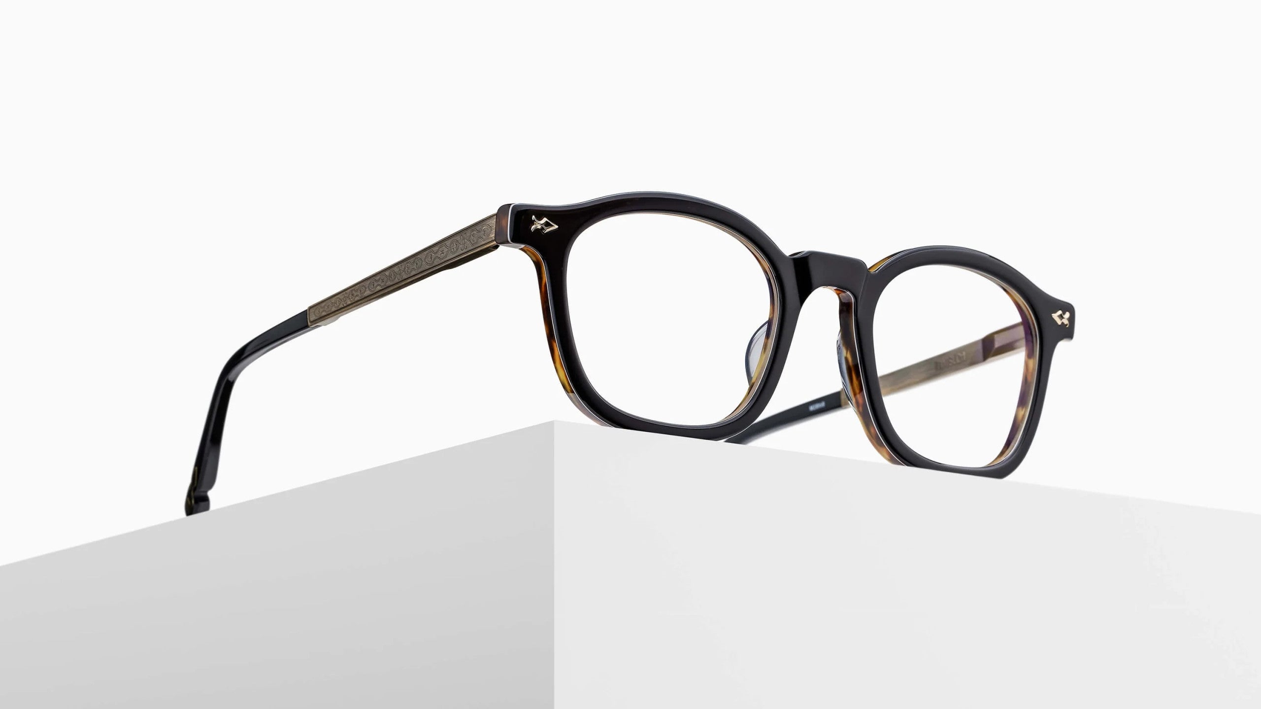 The Matsuda M2068 round eyeglasses in dark tortoiseshell with thin arms are displayed on the edge of a white geometric surface against a plain white background.