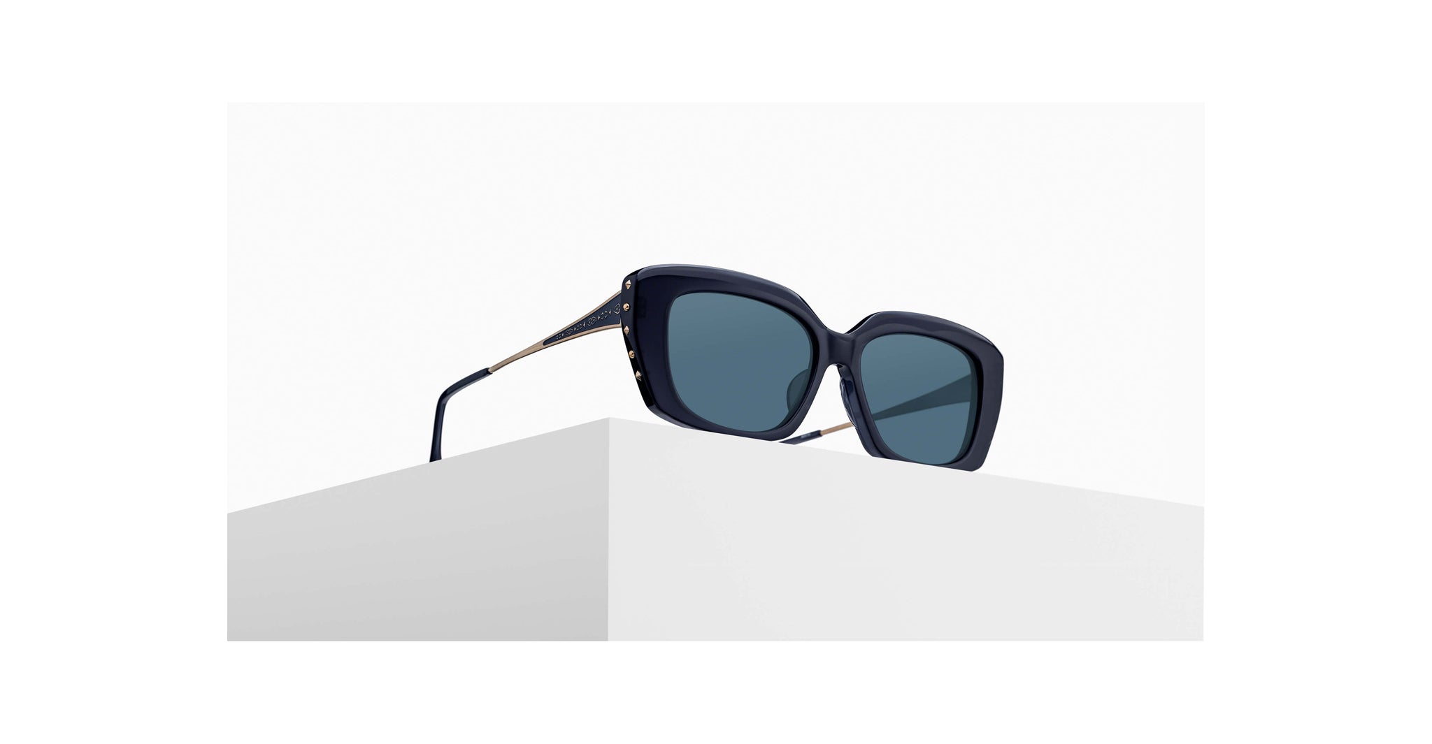 3/4 view of Matsuda sunglass model M2070 in dark navy crystal with blue grey lenses on a pedestal
