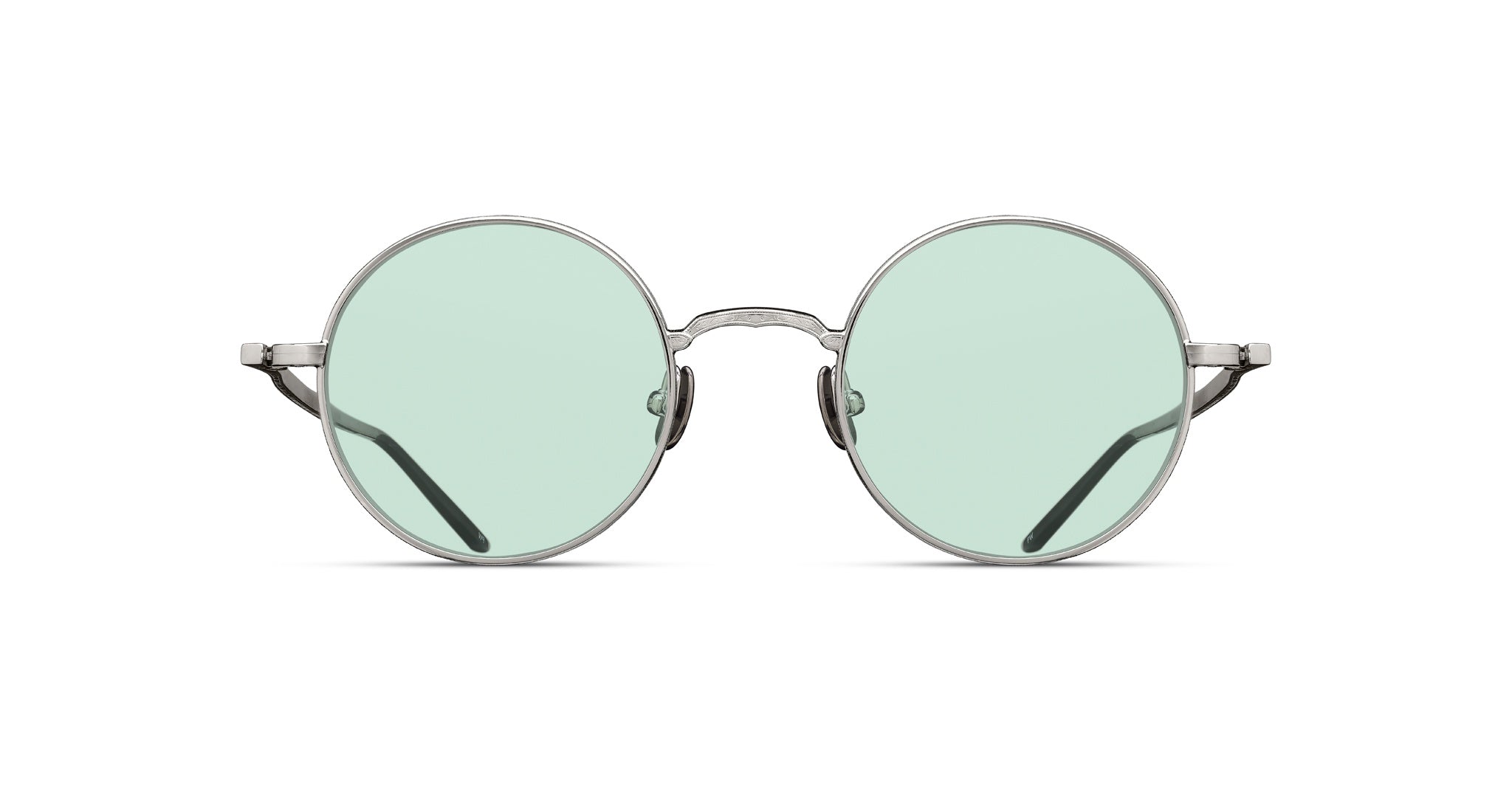 The Matsuda M3087 are round, silver metal-framed eyeglasses with light green tinted lenses, displayed facing forward on a white background.