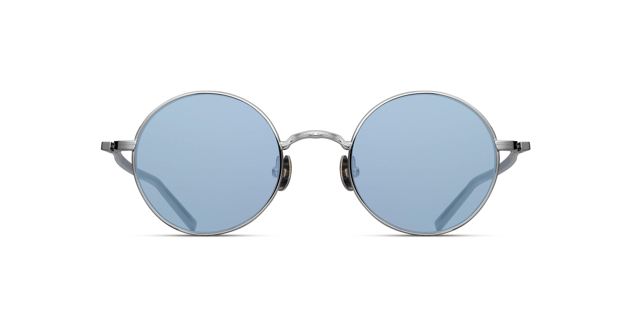 The Matsuda M3087 sunglasses feature round, thin silver metal frames and light blue tinted lenses, shown on a white background.