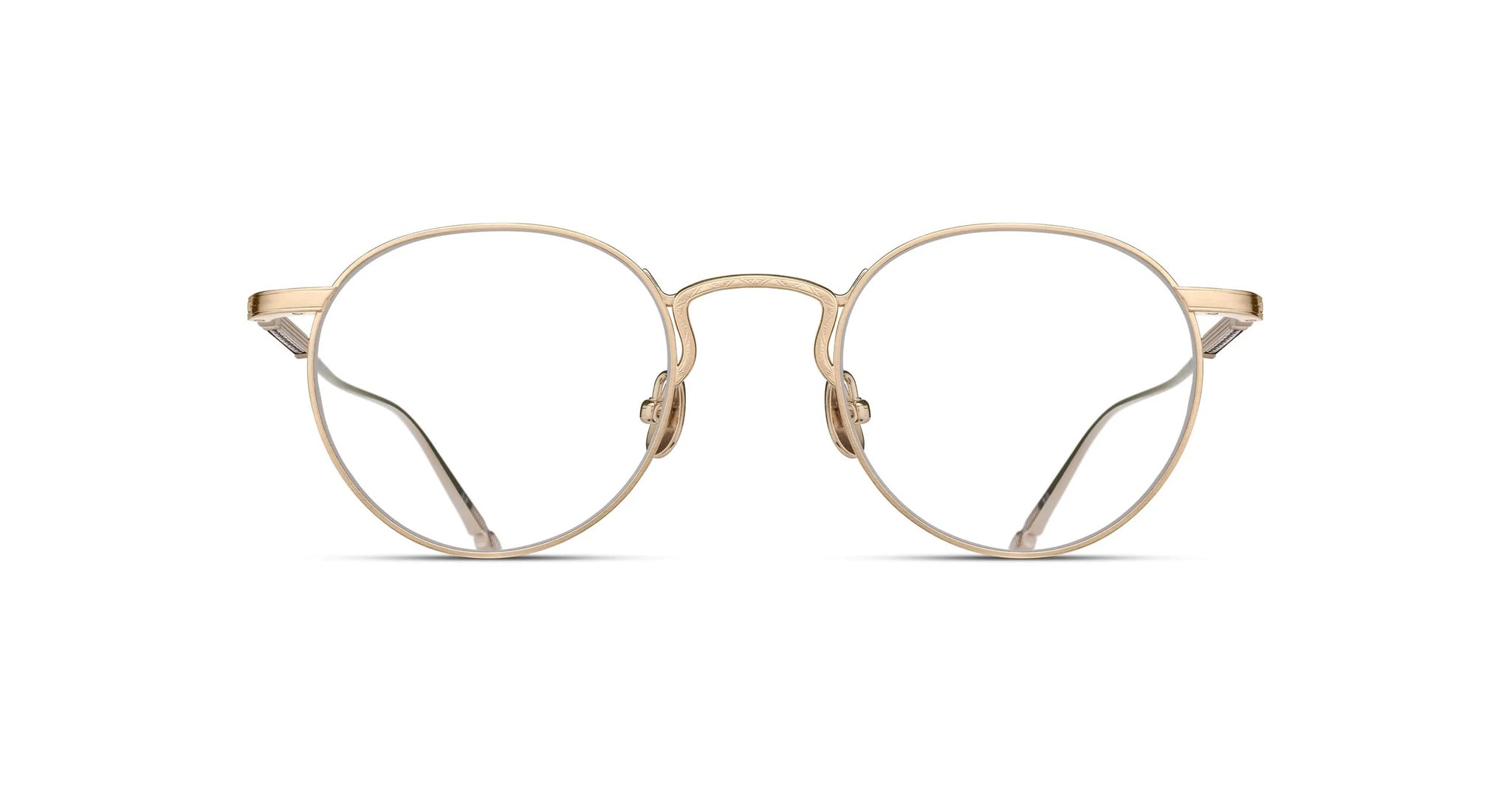 The Matsuda M3140 features round, gold metal eyeglasses with clear lenses and a thin frame, shown from the front on a white background. Visible details include nose pads and straight temples.