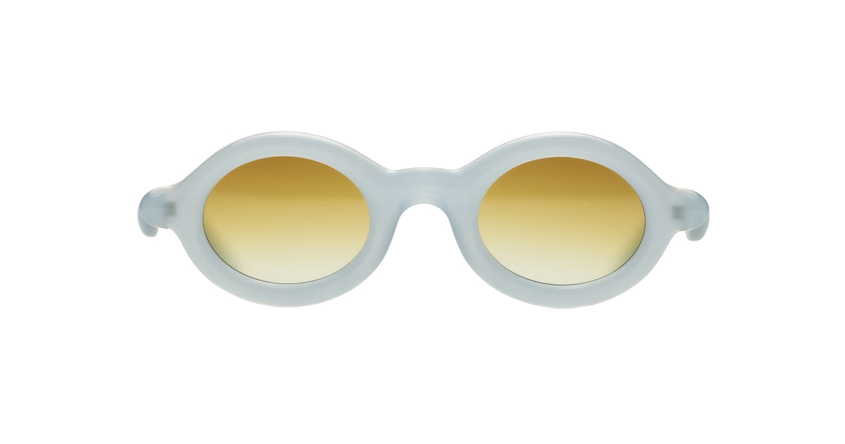 Paloceras Nouvelle Fiction R2 Milky Blue sunglasses in a pale translucent blue frame with thick rounded oval rims and warm golden gradient lenses, front view