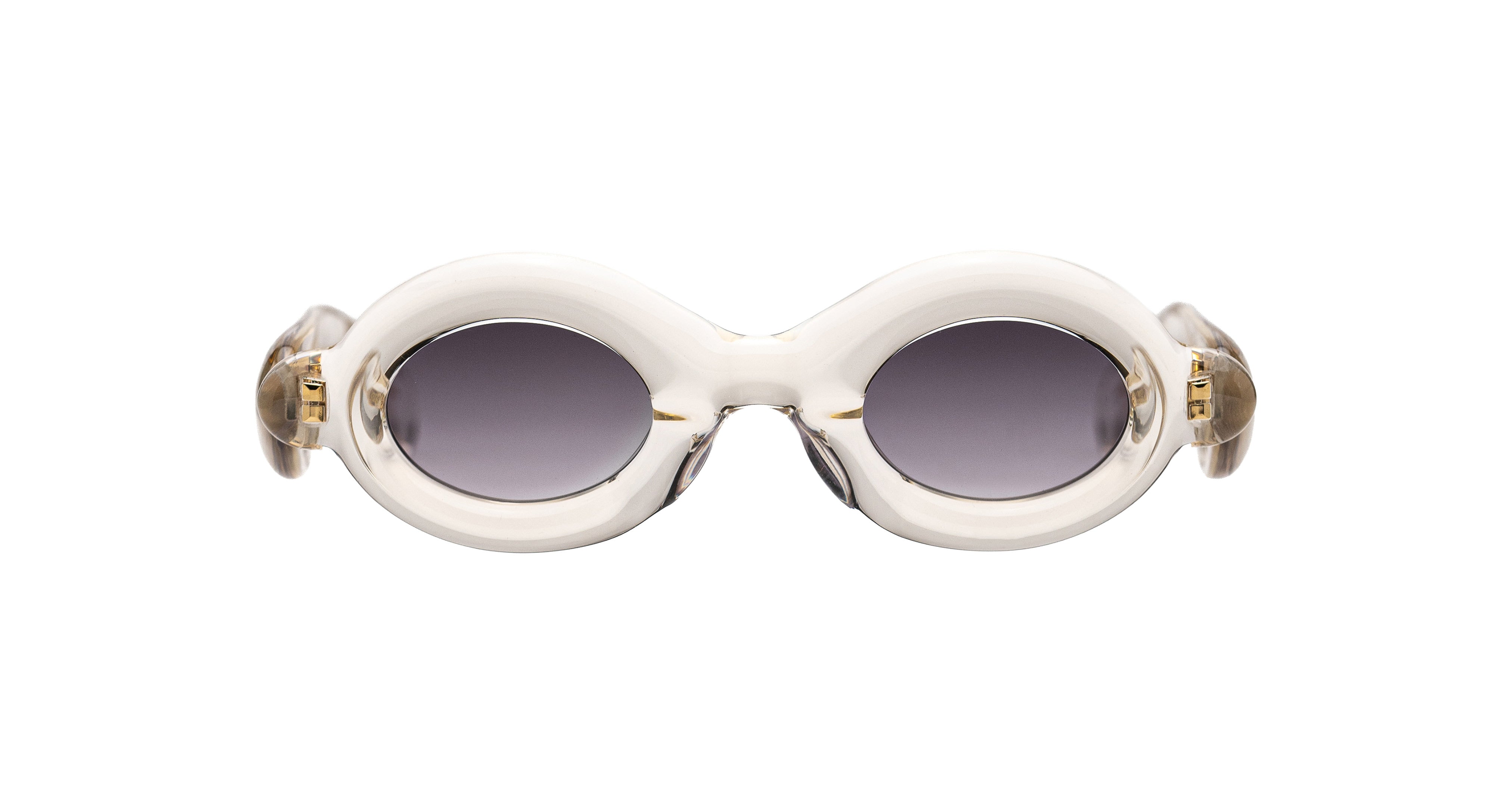 Paloceras Pebble RX Dulce Gloss sunglasses in a clear champagne frame with thick rounded oval rims, gray violet lenses, and gold-tone details, front view