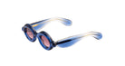 Paloceras Pebble RX oval sunglasses in Ice Blue, with a translucent blue frame and pink lenses, angled view.