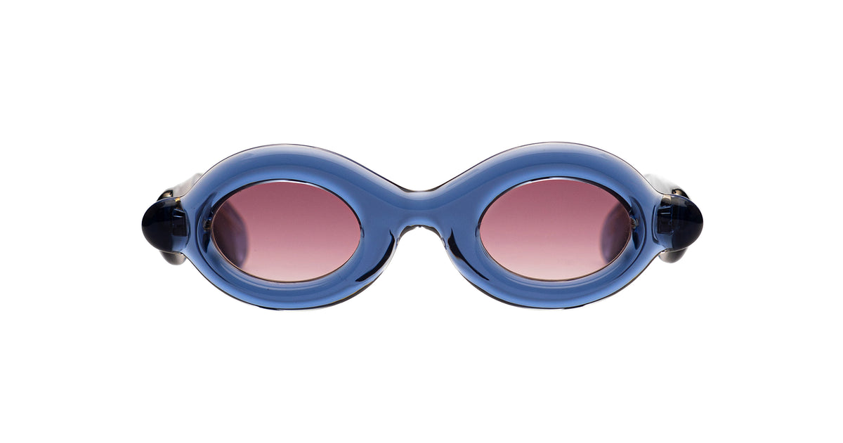 Paloceras Pebble RX oval sunglasses in Ice Blue, with a translucent blue frame and pink lenses, front view.