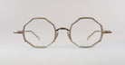 A pair of vintage eyeglasses with thin metal frames and octagonal lenses, viewed from the front against a plain, light background.