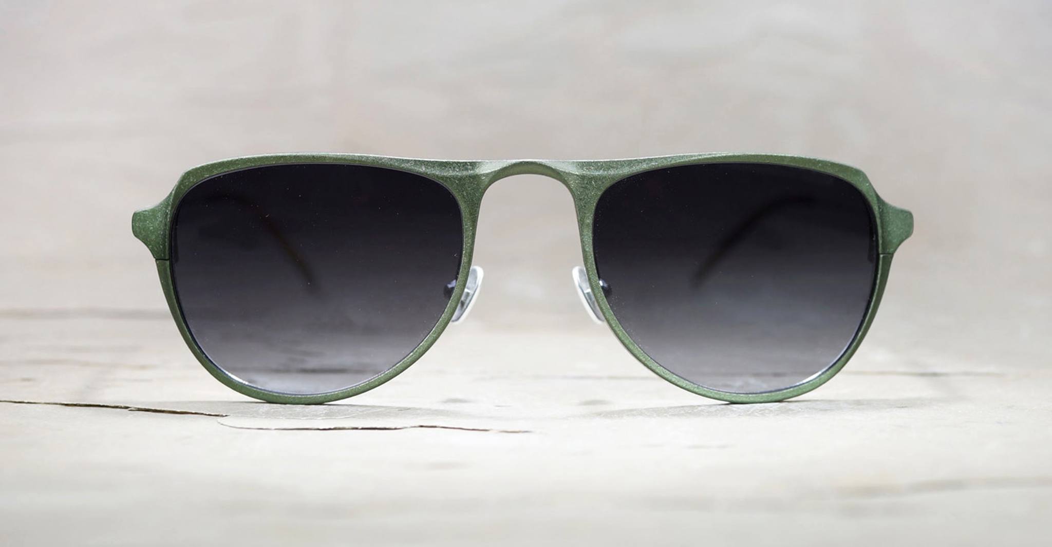 The Rigards RG0101AL aviator sunglasses feature green rims, dark gradient lenses, and lightweight aluminum-magnesium frames, displayed against a light neutral background.