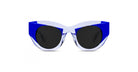 The Thierry Lasry Captivity features thick, angular blue and white frames and large, round black lenses, shown on a white background.