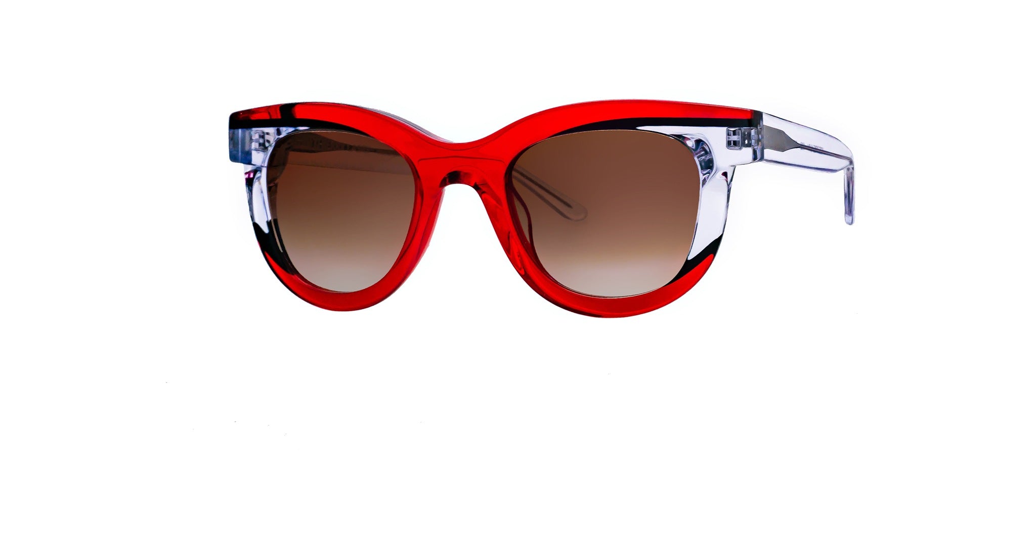 The Thierry Lasry Icecreamy sunglasses feature round lenses with a brown gradient tint and a bold red and clear plastic frame, shown on a white background.
