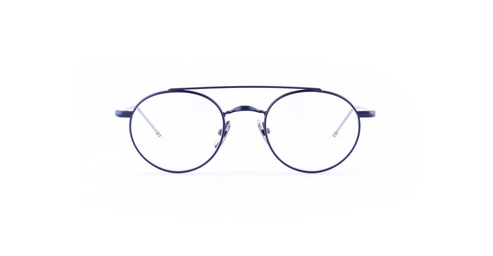 The Thom Browne 101 features round, black-rimmed eyeglasses with thin metal frames and clear lenses, displayed against a white background.