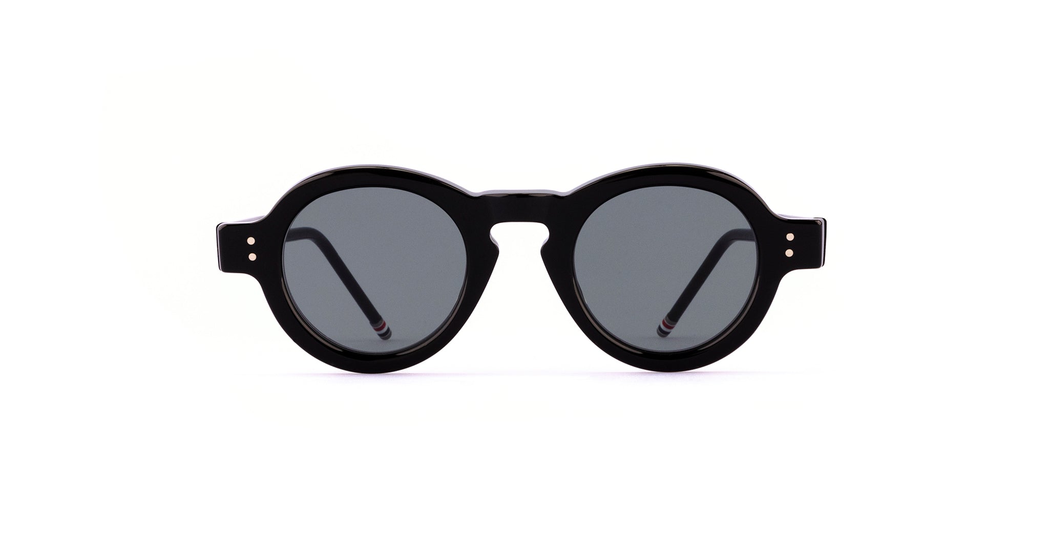 The Thom Browne 922 sunglasses feature round black frames with dark lenses, displayed from the front against a white background.