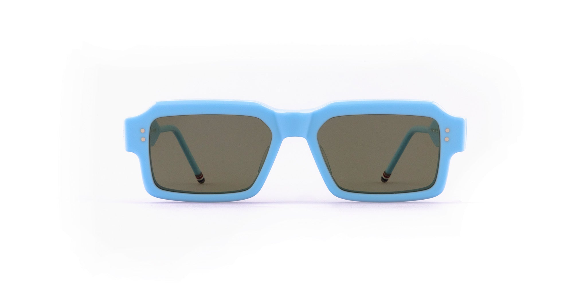 A pair of rectangular Thom Browne sunglasses with thick, light blue frames and dark tinted lenses, shown from the front against a white background.