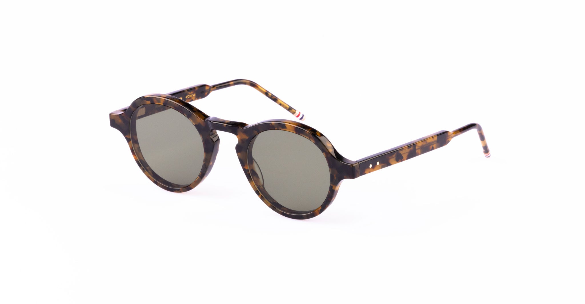 Thom Browne 926 round sunglasses with tortoiseshell frames and dark lenses, displayed on a white background. The arms feature a matching tortoiseshell pattern ending in subtle stripes.