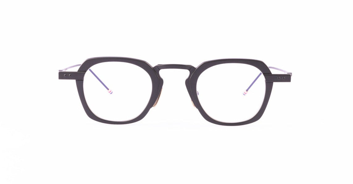 Thom Browne 930 round black eyeglasses with clear lenses are centered on a white background, viewed from the front.