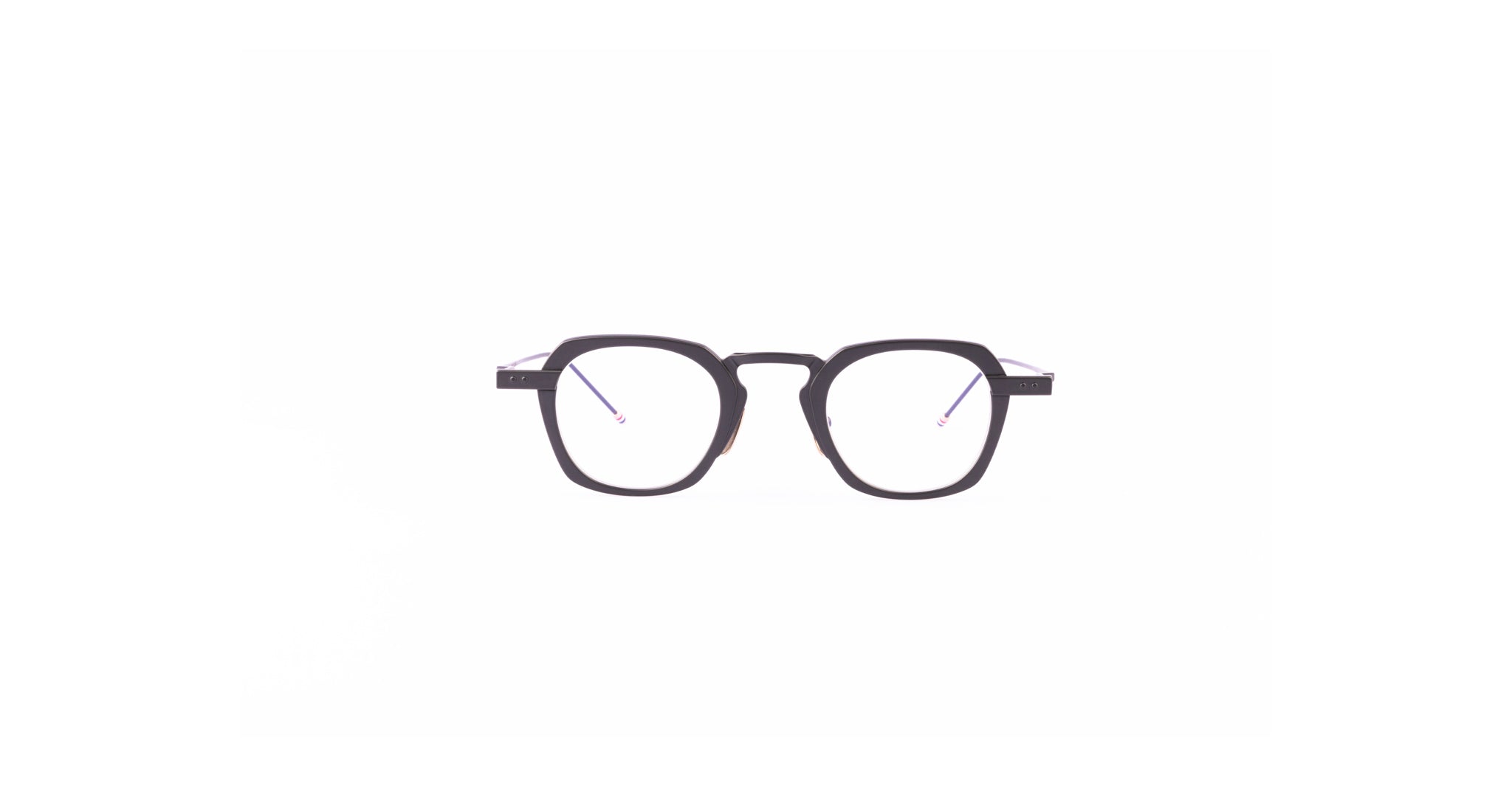 Thom Browne 930 round black eyeglasses with clear lenses are centered on a white background, viewed from the front.