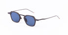 A pair of black-framed metal Thom Browne sunglasses with blue-tinted round lenses and thin metal arms.