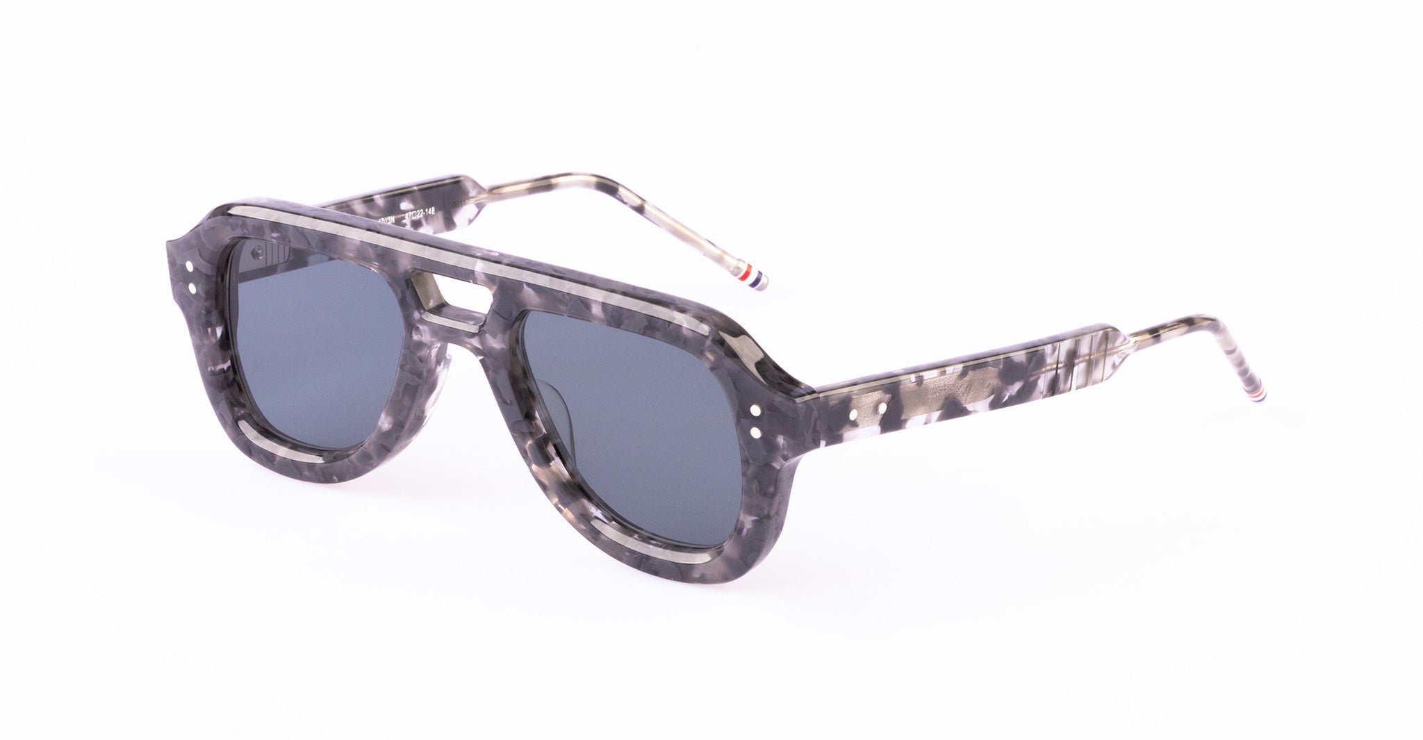 A pair of Thom Browne sunglasses with a thick, marbled gray and black frame, dark lenses, and straight arms with a subtle striped detail near the tips.