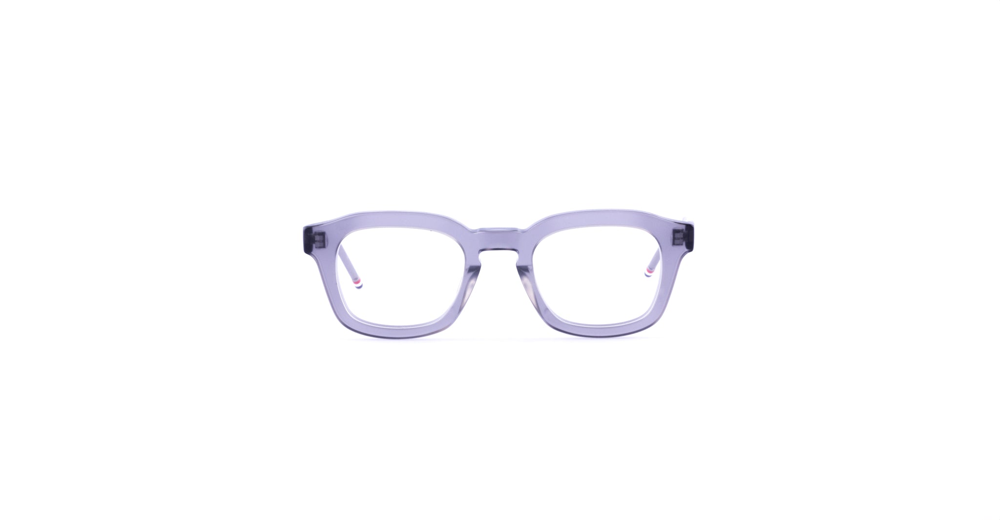Centered on a white background is the Thom Browne 412: clear, light grey eyeglasses with thick, rectangular frames.