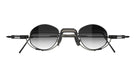 The VOA Nivara sunglasses feature a round, black and silver frame with dark gradient lenses, a unique geometric metal bridge, and modern detailing on the temples, shown against a white background.
