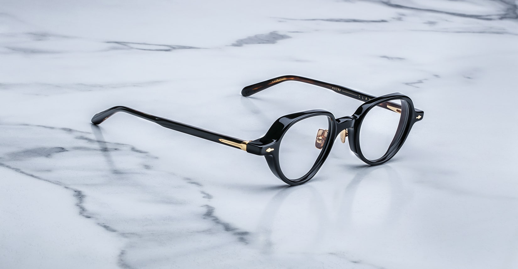 Jacques Marie Mage The Clark black round eyeglasses with gold accents, front view.