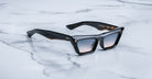 Jacques Marie Mage Debbie in Noir acetate cat-eye frame with gradient gray lenses, featuring gold arrowhead pins and sculpted temples with exposed wirecore