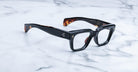 Jacques Marie Mage Fellini black rectangular eyeglasses, thick frames with brown tortoiseshell accents, front view.