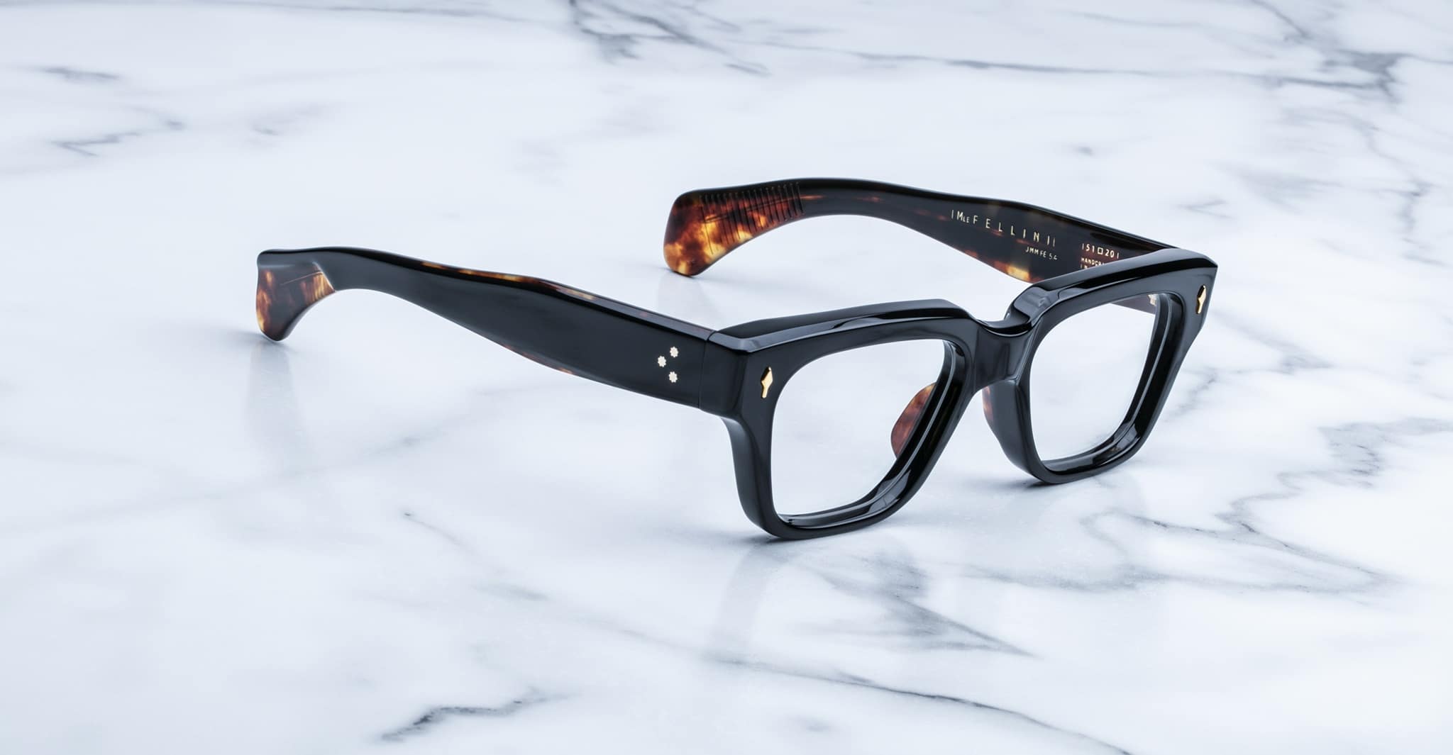 Jacques Marie Mage Fellini black rectangular eyeglasses, thick frames with brown tortoiseshell accents, front view.