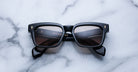Jacques Marie Mage Molino black rectangular sunglasses with polarized lenses, top-down view.