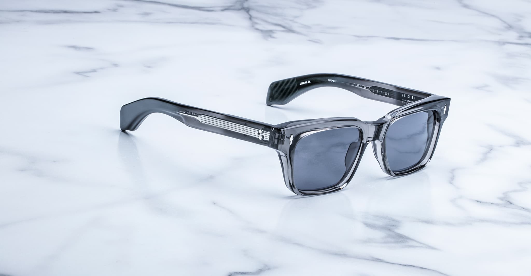 Jacques Marie Mage Molino sunglasses with gray frames and dark lenses, viewed from above.