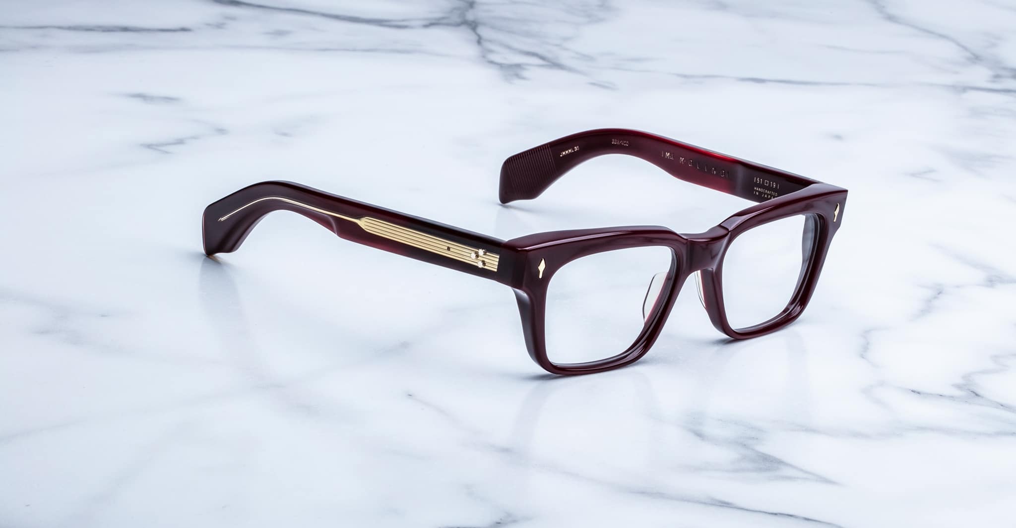 Jacques Marie Mage Molino rectangular maroon eyeglasses with thick frames and gold temple trim, shown from above.