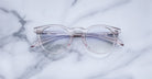 Jacques Marie Mage Percier clear round eyeglasses with pink-tinted arms, closed, viewed from above.