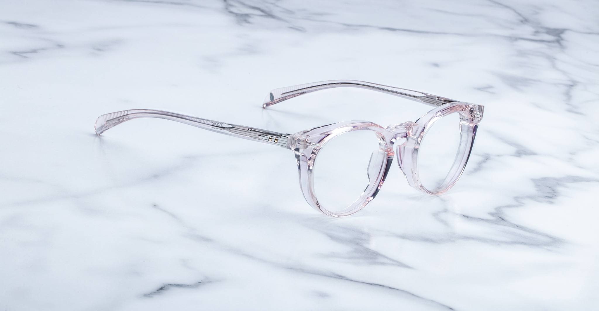 Jacques Marie Mage Percier round eyeglasses with transparent pink acetate frames, front view.