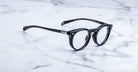 Jacques Marie Mage Percier black round eyeglasses with thick frames, front angle.