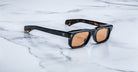 Jacques Marie Mage Saint sunglasses with black rectangular frames and brown lenses, viewed from the front.