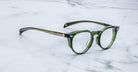Jacques Marie Mage Sheridan in Rover, translucent green glasses with sculpted brow and gold arrowhead pins angled view