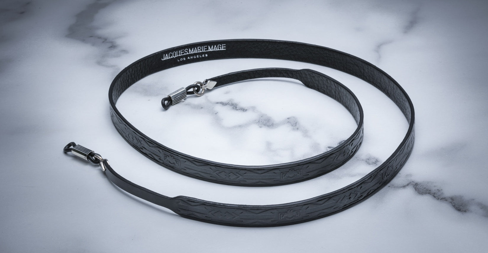 Jacques Marie Mage Strap Tooled eyeglasses strap, black embossed leather with silver clasps, top view.