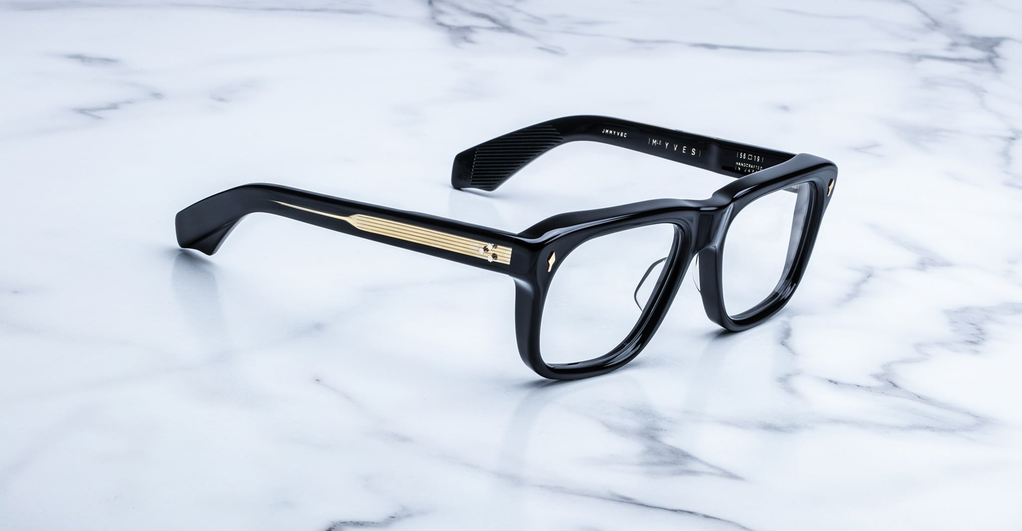 Jacques Marie Mage Yves black rectangular eyeglasses with gold temple detailing, top view.